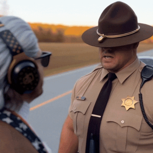 A Man In A Sheriff 'S Uniform Is Talking To Another Man GIF