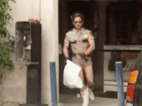 A Man In A Sheriff Uniform Is Carrying A Bag GIF