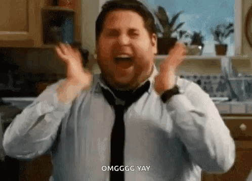A Man In A Shirt And Tie Is Making A Funny Face In A Kitchen . GIF