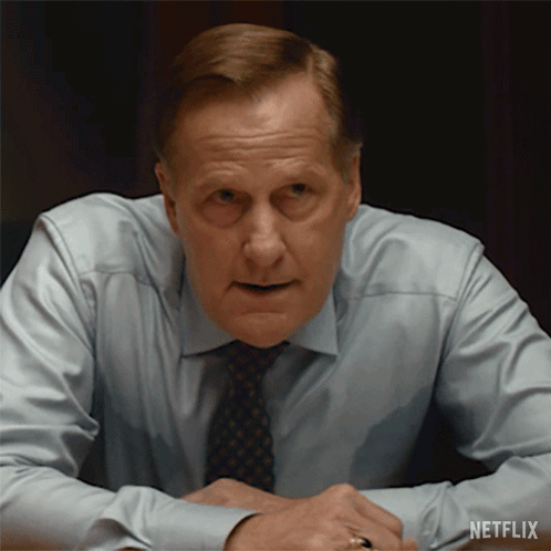 A Man In A Shirt And Tie Is Sitting At A Table With A Netflix Logo On The Bottom Right GIF