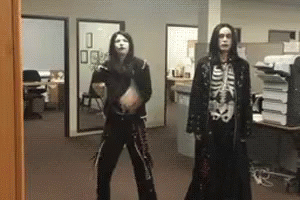 A Man In A Skeleton Costume Is Standing Next To Another Man In A Black Coat GIF
