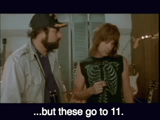 A Man In A Skeleton Shirt Is Talking To Another Man In A Hat ..But These Go To 11 . GIF