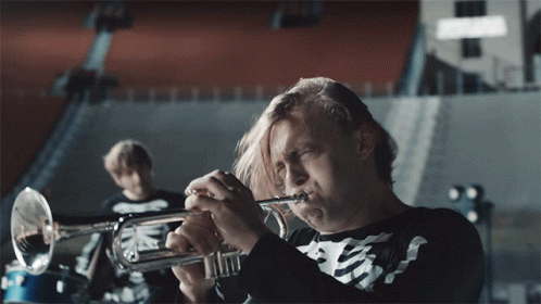 A Man In A Skeleton Shirt Plays A Trumpet In A Band GIF