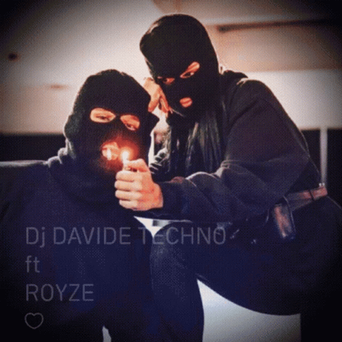 A Man In A Ski Mask Is Lighting A Cigarette Next To A Woman Wearing A Ski Mask GIF