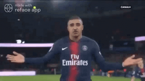A Man In A Soccer Jersey Is Being Hugged By Another Man GIF