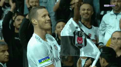a man in a soccer uniform holds a flag that says coca cola on it