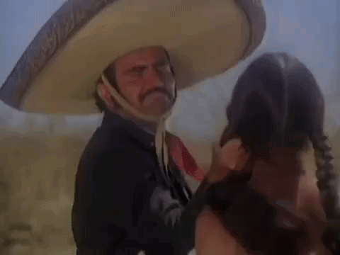 a man in a sombrero is talking to a woman in a field .