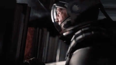 A Man In A Space Helmet Is Looking Out Of A Window . GIF