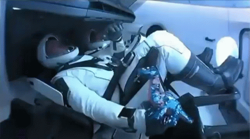 A Man In A Space Suit Is Laying In A Chair In A Space Ship . GIF