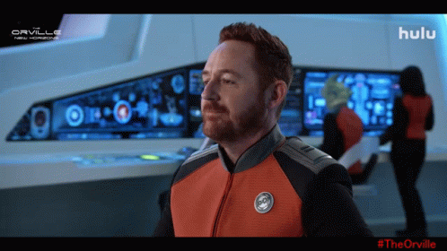 A Man In A Space Suit Is Standing In Front Of A Screen That Says Hulu On It GIF