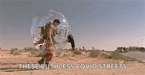 a man in a space suit is walking down a road .