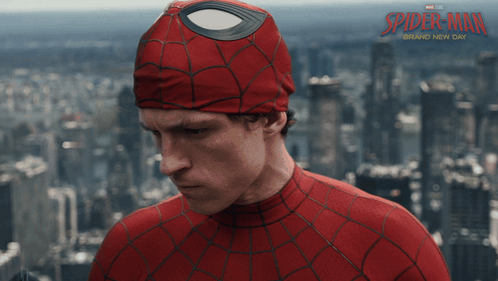 A Man In A Spider Man Costume Stands In Front Of A City Skyline GIF