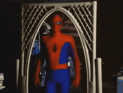 a man in a spider man costume stands in front of a white archway