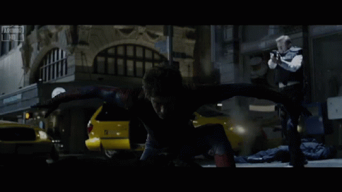 A Man In A Spiderman Costume Is Being Chased By A Man In A Black Vest GIF