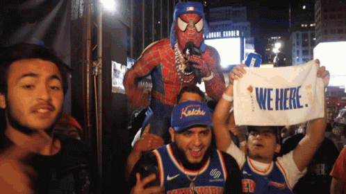 A Man In A Spiderman Costume Is Carrying A Man In A Knicks Jersey On His Shoulders GIF