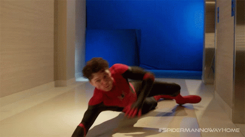 A Man In A Spiderman Costume Is Crawling Down A Hallway GIF