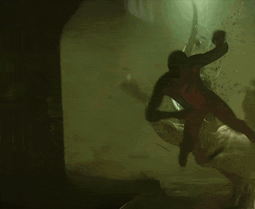 A Man In A Spiderman Costume Is Crawling Through A Dark Cave GIF