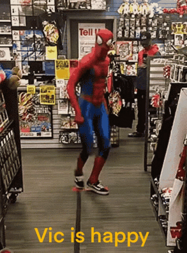 A Man In A Spiderman Costume Is Dancing In A Store With The Words Vic Is Happy Below Him GIF