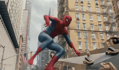A Man In A Spiderman Costume Is Flying Through The Air In A City GIF