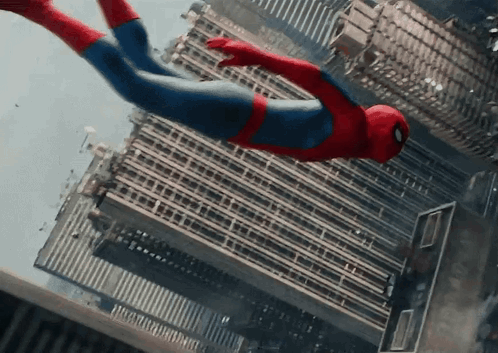 A Man In A Spiderman Costume Is Flying Through The Air Over A City GIF