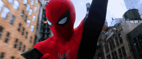a man in a spiderman costume is holding a phone