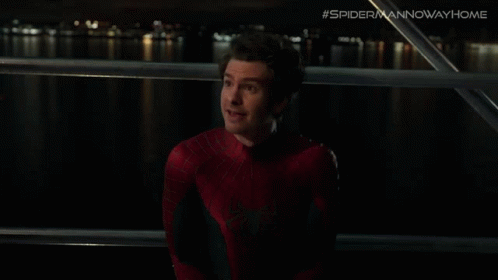 A Man In A Spiderman Costume Is Looking At Something GIF