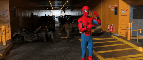 A Man In A Spiderman Costume Is Pointing At Something GIF