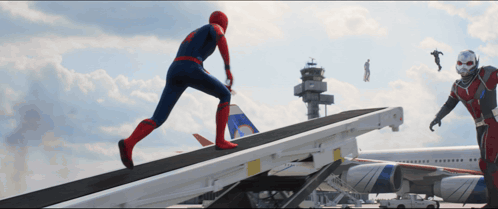 A Man In A Spiderman Costume Is Running Down A Ramp Next To An Ant Man GIF