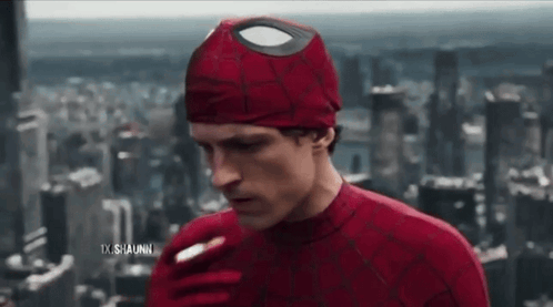 A Man In A Spiderman Costume Is Smoking A Cigarette In Front Of A City Skyline . GIF