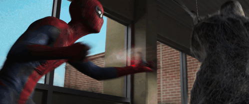 A Man In A Spiderman Costume Is Standing Next To A Cat GIF