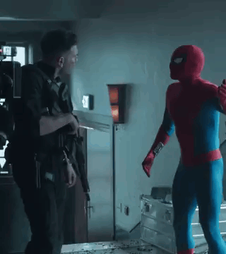 A Man In A Spiderman Costume Is Standing Next To A Man In A Military Uniform Holding A Gun . GIF
