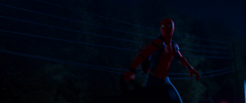 A Man In A Spiderman Costume Is Standing Next To A Power Line At Night GIF