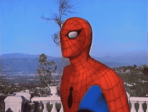 A Man In A Spiderman Costume Is Standing On A Balcony Overlooking A City GIF
