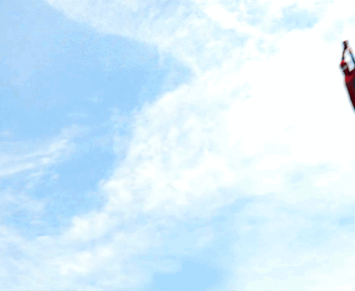 A Man In A Spiderman Costume Is Standing On A Roof GIF