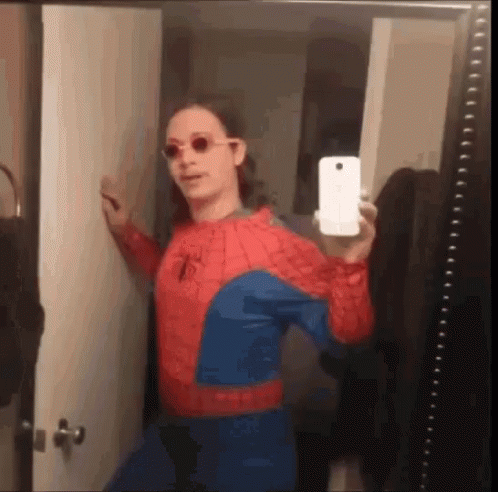 A Man In A Spiderman Costume Is Taking A Selfie In A Bathroom Mirror . GIF