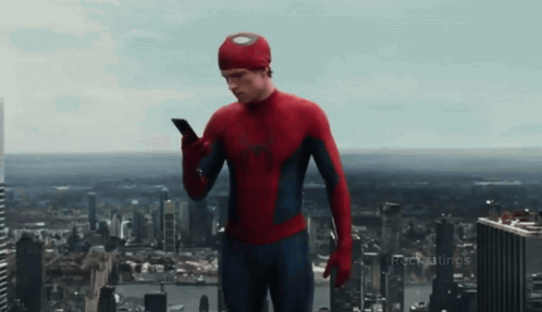 A Man In A Spiderman Costume Is Using A Cell Phone GIF