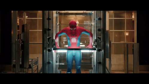 A Man In A Spiderman Costume Stands In An Elevator GIF