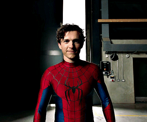 A Man In A Spiderman Costume Stands In Front Of A Door GIF