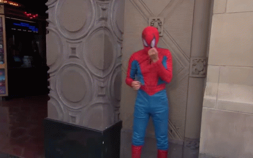 A Man In A Spiderman Costume Stands Next To A Pillar GIF