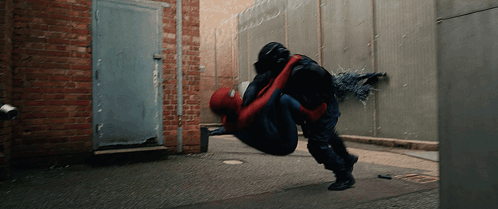 A Man In A Spiderman Suit Is Being Lifted In The Air By Another Man GIF