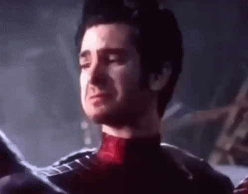 A Man In A Spiderman Suit Is Crying With His Eyes Closed In A Dark Room . GIF