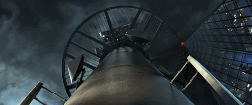 A Man In A Spiderman Suit Is Fighting A Dinosaur GIF