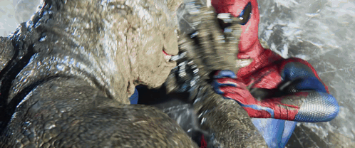 A Man In A Spiderman Suit Is Fighting A Giant Monster GIF