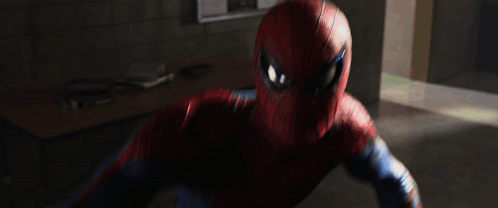 A Man In A Spiderman Suit Is Fighting A Monster In A Hallway GIF