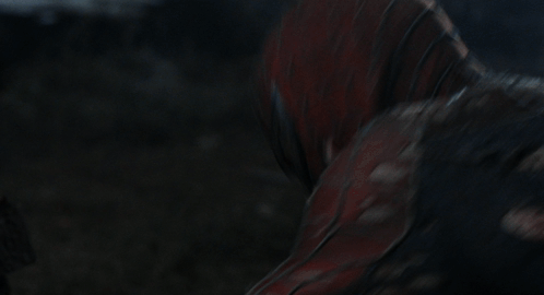 A Man In A Spiderman Suit Is Holding A Spider Web In His Hand GIF