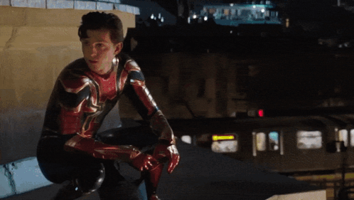 A Man In A Spiderman Suit Squatting Down GIF