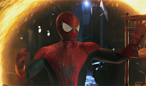 A Man In A Spiderman Suit Stands In Front Of A Fire GIF