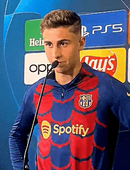A Man In A Spotify Shirt Is Standing In Front Of A Microphone . GIF