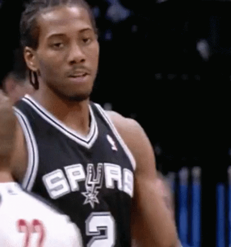 A Man In A Spurs Jersey Is Looking At Something GIF