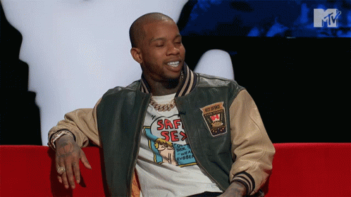 A Man In A Srf Sex Shirt Sits On A Couch GIF